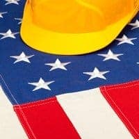 Construction helmet laying over US flag - closeup shoot