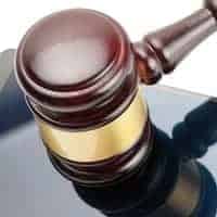 Smartphone under judge gavel over it - studio shot on white